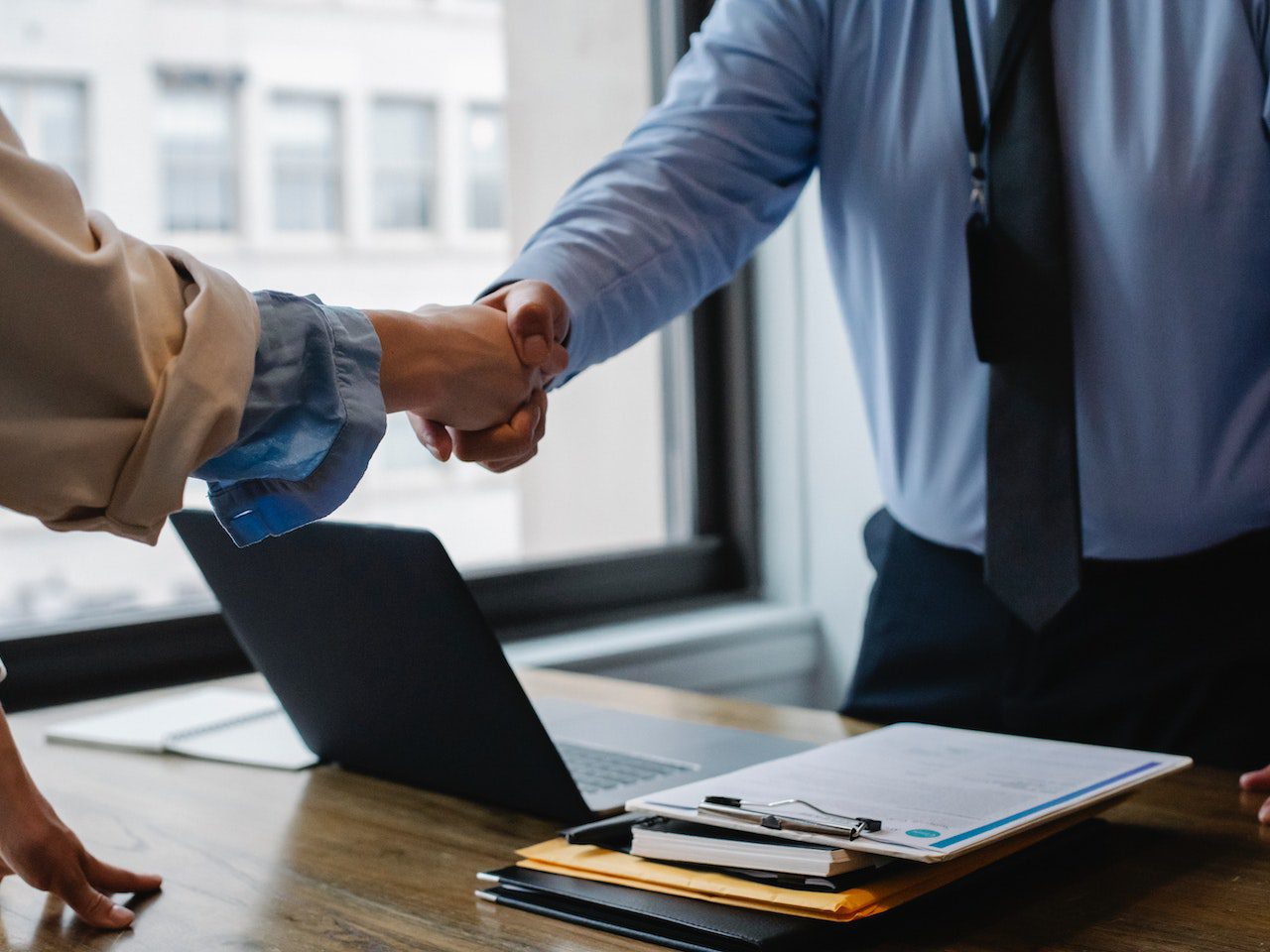 Crop colleagues shaking hands in office<br />
